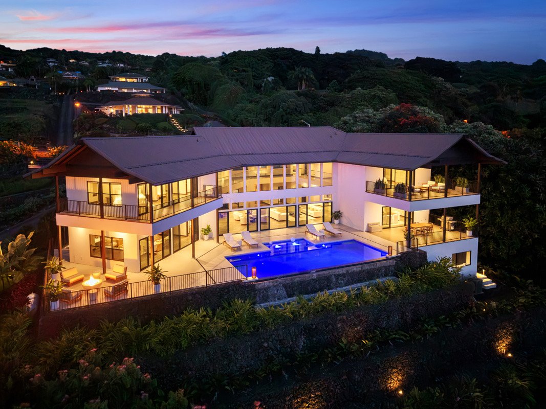 Hillside estate and pool at dusk above the Kona coast